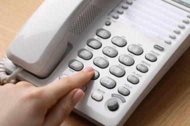 Ahşap masada telefonla arayan kadın, yakın plan.