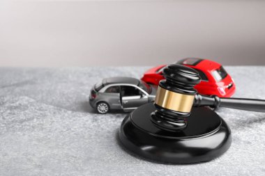 Motorlu taşıt kazası yasası. Gavel ve araba modelleri gri arka planda. Metin için boşluk