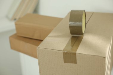 Kapalı alanda yapıştırıcı bantlı karton kutu kapatılıyor.