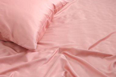 Güzel pembe ipek çarşaflı yatak, yakın plan. Metin için boşluk