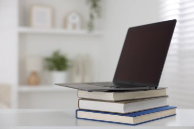 Beyaz masa içerisindeki farklı kitap ve dizüstü bilgisayar. Metin için boşluk