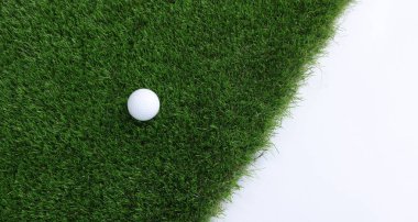 Beyaz arka planda golf topu ve yeşil çimenler, üst manzara. Metin için boşluk