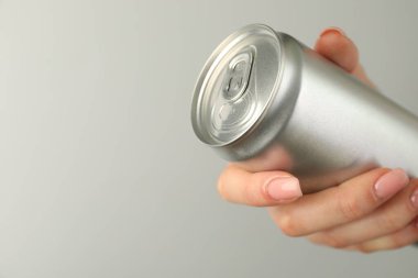 Açık gri arka planda teneke kutusu olan kadın, yakın plan. Metin için boşluk