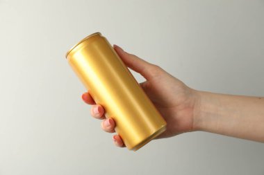 Açık gri arka planda teneke kutusu olan kadın, yakın plan.