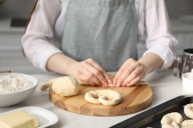 Mutfaktaki masada simit şekillendiren kadın, yakın plan.