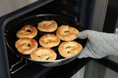 Fırından taze krakerlerle fırın yapan kadın, yakın plan.