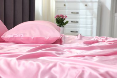 Lüks ipek çarşaflar evdeki yatakta, yakın plan.