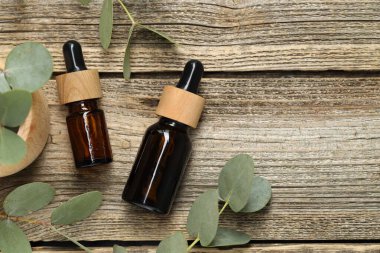 Kaliteli yağ ve okaliptüs yaprakları ahşap masada, düz yerde. Metin için boşluk