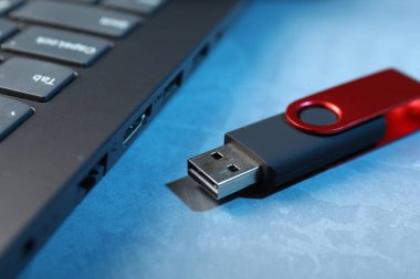 Mavi desenli masadaki USB flash disk ve dizüstü bilgisayar, yakın plan