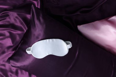 Lüks ipek çarşaflar, yastık ve uyku maskesi, üst manzara.