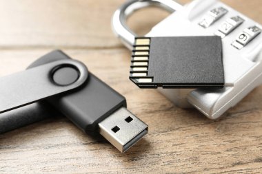 Flaş bellek, hafıza kartı ve ahşap arka planda asma kilit kombinasyonu, yakın plan.