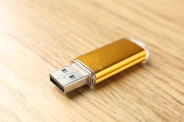 Tahta arka planda bir flaş bellek, yakın plan. Metin için boşluk