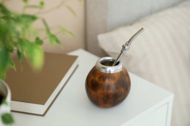 Geleneksel yerba mate çayı ve kitap komodinin içinde.