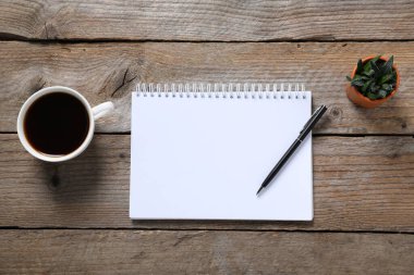 Kalem, açık defter, kahve ve çiçek dekoru ahşap masa, düz uzanma