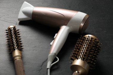 Yuvarlak fırçalar ve kurutma makineleri siyah masanın üstünde.