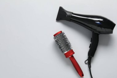 Beyaz arka planda saç kurutma makinesi ve fırça, üst manzara. Metin için boşluk
