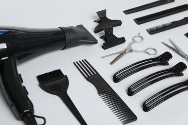 Beyaz arkaplanda farklı saç şekillendirme araçları, yakın plan