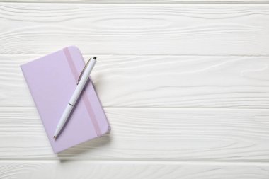 Kalem ve defter beyaz ahşap masa, üst manzara. Metin için boşluk