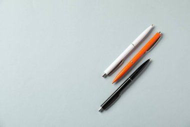 Gri arka planda şık kalemler, düz yatış. Metin için boşluk