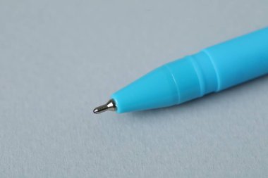 Gri arka planda bir tükenmez kalem, makro görüş. Metin için boşluk