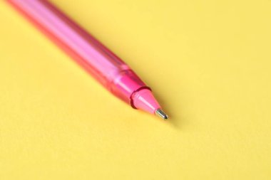 Sarı arka planda bir tükenmez kalem, makro görüş. Metin için boşluk
