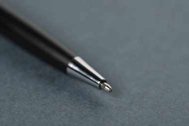 Gri arka planda şık bir kalem, makro görünüm. Metin için boşluk