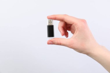 Açık gri arka planda modern flash diski olan adam, yakın plan. Metin için boşluk