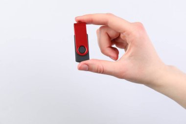 Açık gri arka planda modern flash diski olan adam, yakın plan. Metin için boşluk