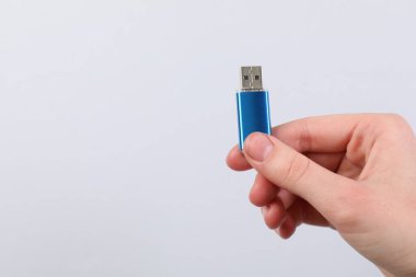 Açık gri arka planda modern flash diski olan adam, yakın plan. Metin için boşluk