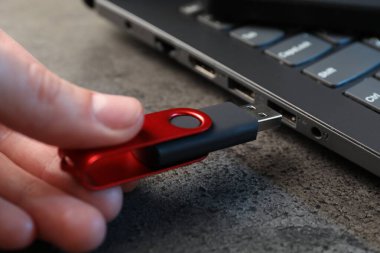 Adam modern flash belleği gri masaya yerleştiriyor, yakın plan.