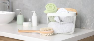 Sepetteki temiz havlular, kozmetik ürünler ve kapalı alandaki makyaj malzemeleri.