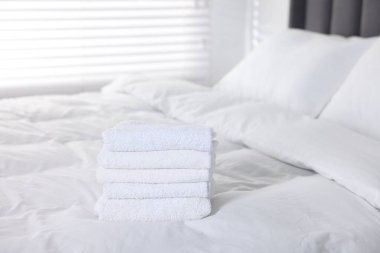 Evdeki yatakta temiz havlu var.