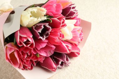 Beyaz desenli masa üzerinde güzel laleler, yakın plan. Metin için boşluk