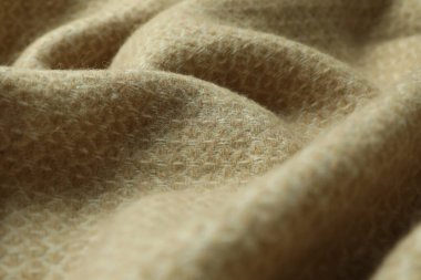 Geometrik desenli bej yün kumaş, yakın plan.