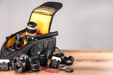 Profesyonel fotoğrafçının ekipmanı ve sırt çantası ahşap masada. Metin için boşluk