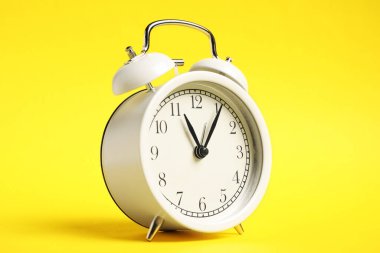 Sarı arkaplanda bir beyaz alarm saati