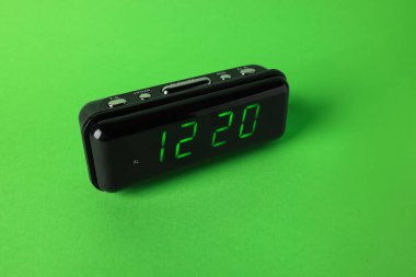 Saat 12: 20 'de yeşil arkaplanda dijital alarm var.