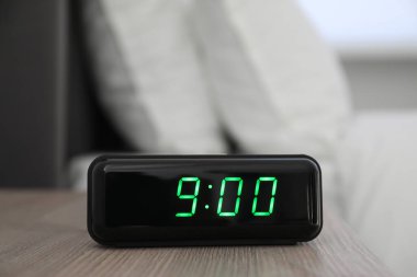 Dijital alarm saat 9: 00 'da kapalı bir masada.