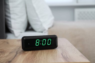 Dijital alarm saat 8 'de kapalı bir masada.