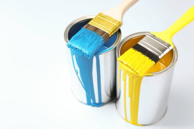 Cans of paint and brushes on light background. Space for text