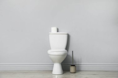 Kapalı alanda seramik klozet, fırça ve kağıt.