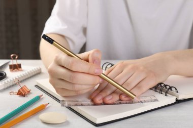 Işık masasında cetvel ve kalemle çizim yapan kadın, yakın plan.