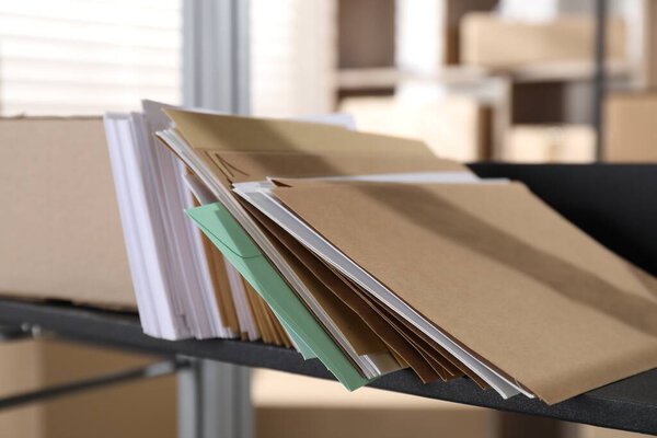 Many different envelopes on shelf in post office