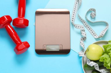 Elektronik mutfak ölçeği, mezura, açık mavi zemin üzerinde dambıl ve ürünler, düz zemin. Diyet