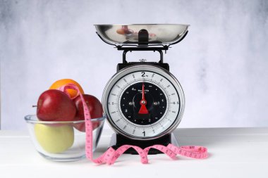 Meyveli mutfak pulları ve beyaz ahşap masadaki mezura.