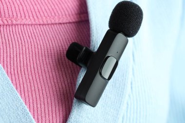 Gömleğinde lavalier mikrofon olan bir kadın, yakın plan.