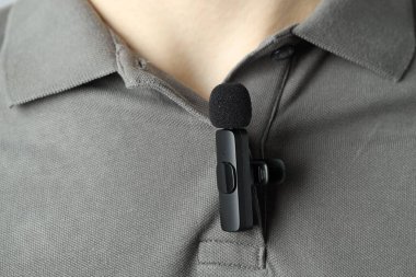 Polo tişörtüne mikrofon takmış bir adam.