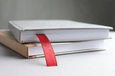 Kırmızı kurdele yer imine sahip bir kitap ve gri arkaplan üzerinde renkli bir tablo, yakın plan