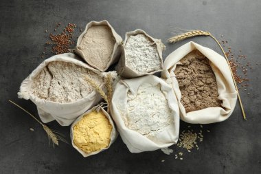 Gri masadaki poşetlerdeki farklı un türleri, düz yatıyordu.