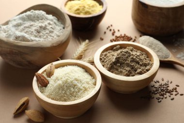 Açık kahverengi masada farklı tipte un, yakın plan.